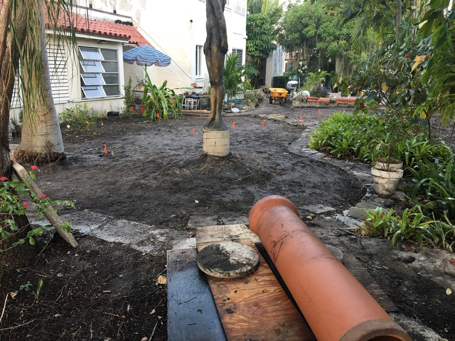 Residential garden under preparation with marked soil, retained trees and landscape materials
